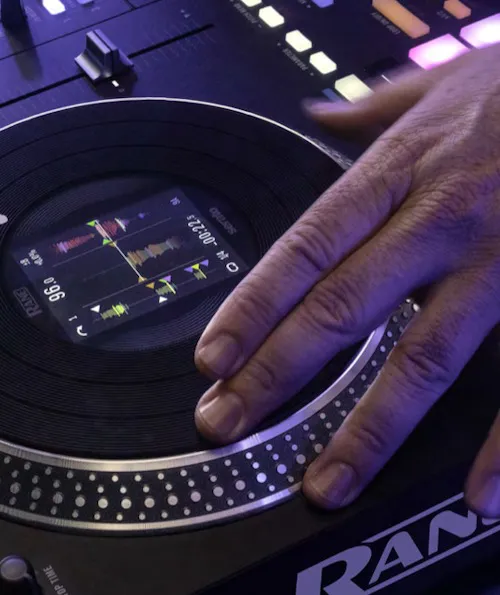 Primer plano de la rueda jog del controlador DJ Rane Performer con pantalla visualizando las formas de onda. La rueda jog es táctil y precisa, permitiendo al DJ realizar scratch y ajustes detallados en las mezclas.