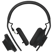 Vista de los auriculares AIAIAI TMA-2 MOVE XE con las cápsulas desmontadas, mostrando su modularidad. Se observa un conector de 3.5 mm para intercambiar componentes fácilmente, con almohadillas de tela transpirables y diseño ergonómico.