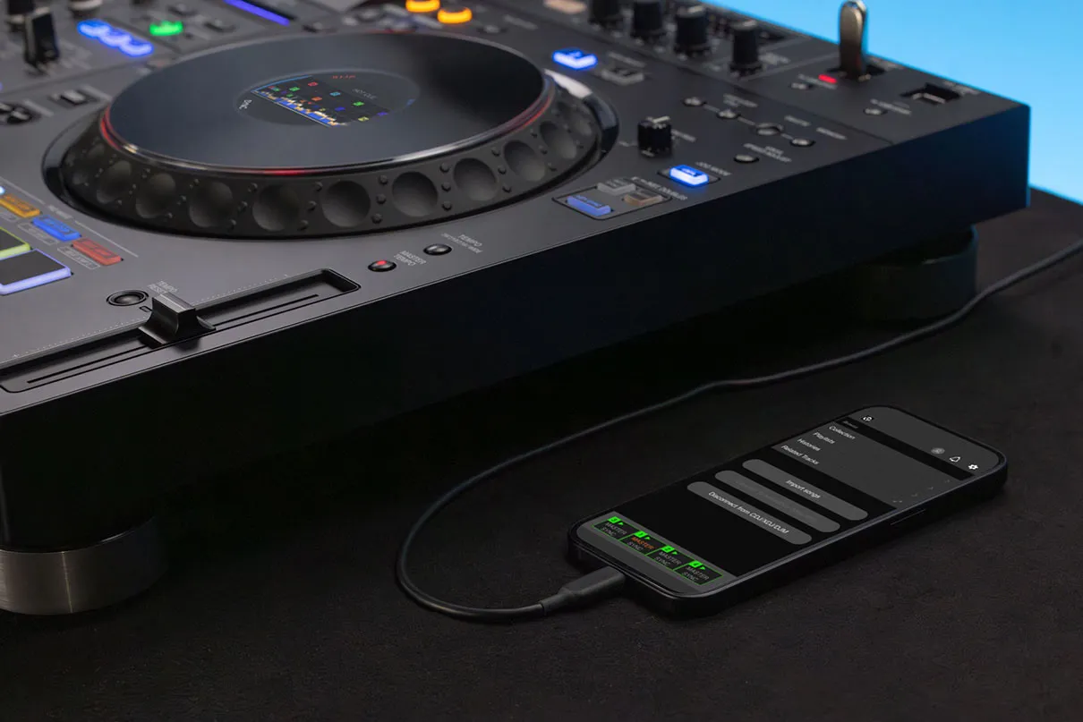 Detalle de smartphone conectado por cable al sistema XDJ-AZ-N para gestionar librerías de música y conectividad remota.