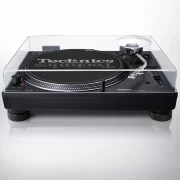 Vista frontal del giradiscos de tracción directa Technics SL-1210MK7 con la cubierta antipolvo transparente de policarbonato instalada, protegiendo el plato giratorio y el mecanismo del brazo.